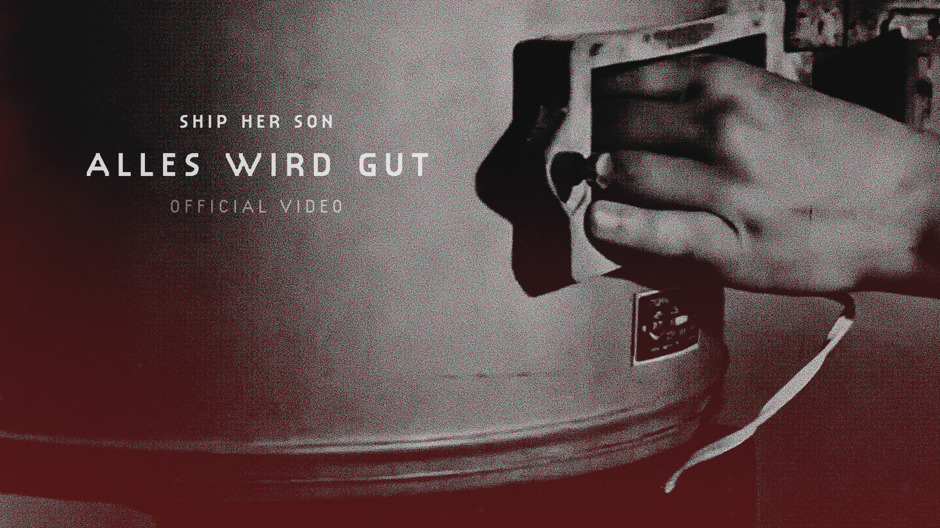 Alles wird gut — hand holding a tape spool, deep red tone